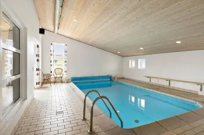 a swimming pool in a room with a wooden ceiling at 803-Harboore-Merchantvej-9-A in Harboør