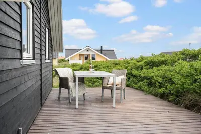a table and chairs sitting on a deck at 805-Harboore-Vejlby-klit-247 in Harboør