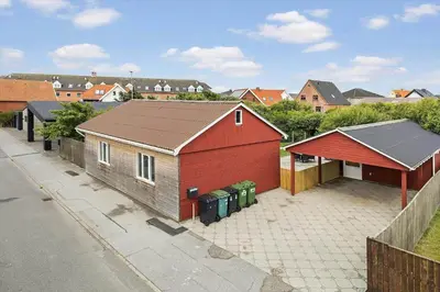 a red building with two trash cans next to a street at 727-Thyboron-Magevej-10 in Thyborøn