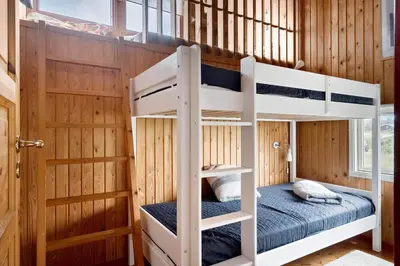 a bunk bed in a wooden room with a bunk bed in a house at 807-Harboore-Dalevej-9 in Harboør