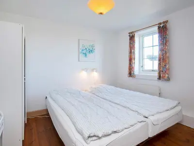 a white bedroom with a bed and a window at 12 person holiday home in Lemvig in Lemvig