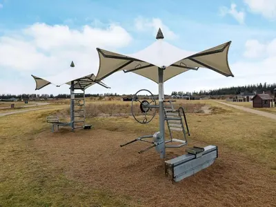 two playground equipment in a field with a sky at Tranquil Retreat in Nature s Embrace-By Traum in Brovst