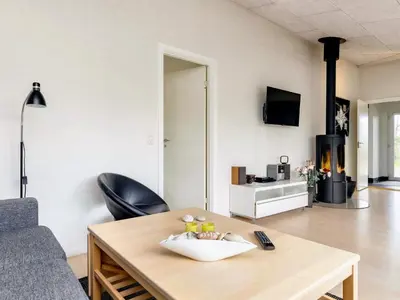 a living room with a table and a couch at Tranquil Retreat in Nature s Embrace-By Traum in Brovst