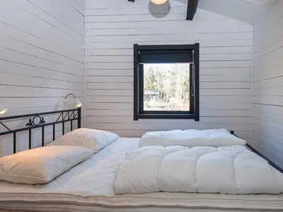 a large white bed in a room with a window at 4 person holiday home in Nibe-By Traum in Nibe