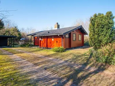 a small house on a field next to a dirt road at 4 person holiday home in Nibe-By Traum in Nibe