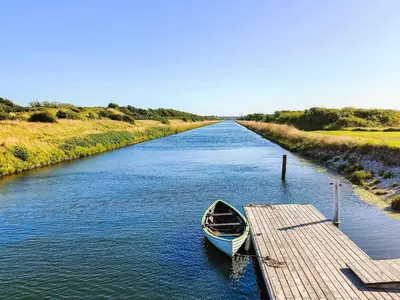 a boat is docked at a dock on a river at 5 person holiday home in Løgstør in Løgstør