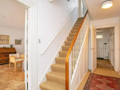 a staircase in a home with white walls and wood floors at 5 person holiday home in Løgstør in Løgstør
