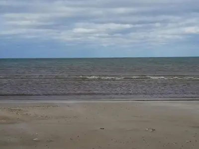 a beach with the ocean on a cloudy day at 12 person holiday home in Saltum-By Traum in Saltum