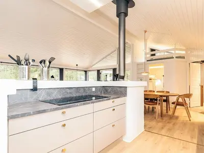a kitchen with white cabinets and a dining room at 12 person holiday home in Saltum-By Traum in Saltum