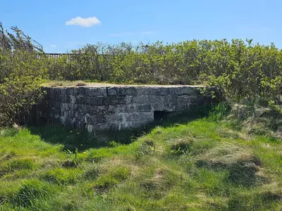 an old stone wall in a field of grass at 10 person holiday home in Harboøre-By Traum in Harboør