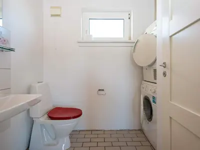 a white bathroom with a red toilet and a window at 10 person holiday home in Harboøre-By Traum in Harboør