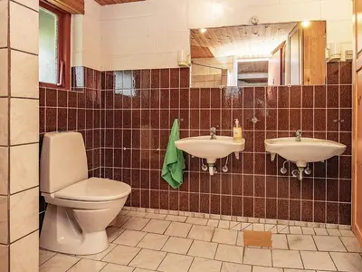 a bathroom with two sinks and a toilet and a mirror at 10 person holiday home in Fur in Fur