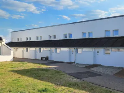 a large white building with a black roof at Seaside Serenity in TAYsinge-By Traum in Brovst
