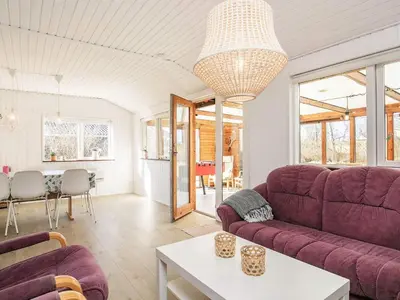 a living room with a purple couch and a table at 8 person holiday home in Vinderup-By Traum in Vinderup