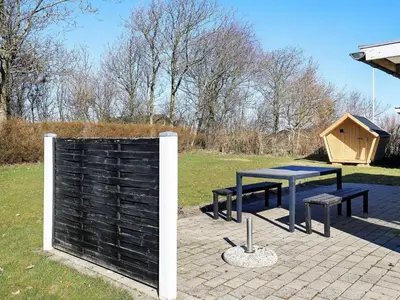 a picnic table and a dog house in a yard at 8 person holiday home in Vinderup-By Traum in Vinderup