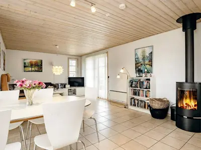 a living room with a fireplace and a table and chairs at 6 person holiday home in Brovst-By Traum in Brovst