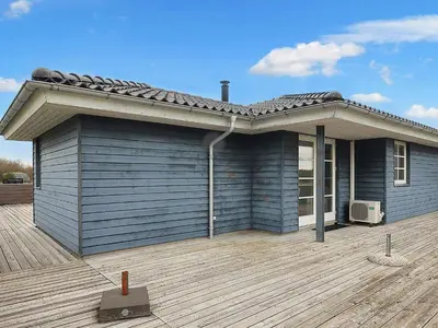 a blue house with a roof on a deck at 6 person holiday home in Brovst-By Traum in Brovst