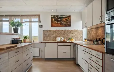 a kitchen with white cabinets and a stone wall at Stunning Home In Harboøre With Wifi in Harboør