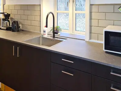 a kitchen counter with a sink and a microwave at Luxury Retreat with Pool - By Traum Ferienwohnungen in Thyholm