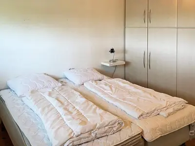 an unmade bed in a bedroom with a cabinet at Scenic Retreat in Boddum - By Traum Ferienwohnungen in Boddum