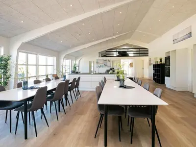 a kitchen and dining room with white tables and chairs at 22 person holiday home in Løkken-By Traum in Løkken