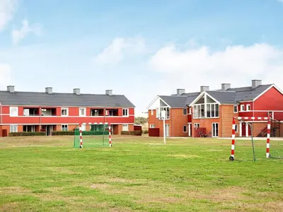a group of houses in a field with a playground at 4 person holiday home on a holiday park in Lemvig in Lemvig