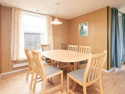 a dining room with a wooden table and chairs at 6 person holiday home in Løkken in Løkken