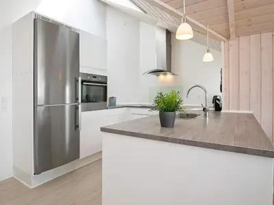 a kitchen with a stainless steel refrigerator and white cabinets at 10 person holiday home in Harboøre in Harboør