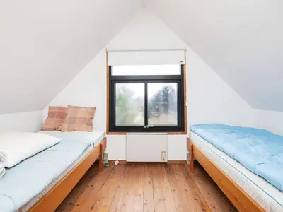 two beds in a room with a window at 6 person holiday home in Pandrup-By Traum in Pandrup