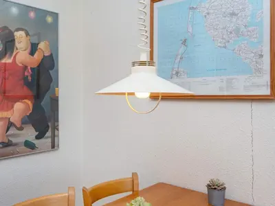 a lamp in a dining room with a picture on the wall at 6 person holiday home in Lemvig-By Traum in Lemvig