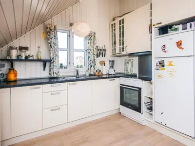a kitchen with white cabinets and a refrigerator at 6 person holiday home in Harboøre-By Traum in Harboør
