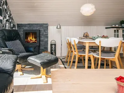 a living room with a table and a fireplace at 6 person holiday home in Harboøre-By Traum in Harboør