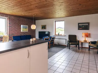 a kitchen and living room with a couch and chairs at 7 person holiday home in Frøstrup in Frøstrup
