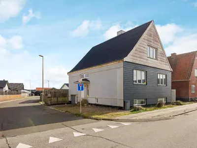 a house with a black roof on the side of a street at 8 person holiday home in Thyborøn-By Traum in Thyborøn