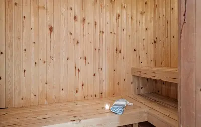 a wooden sauna with a bottle and a candle in it at Cozy Home In Vestervig With Sauna in Vestervig
