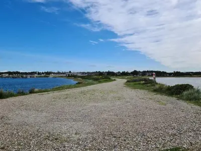a gravel road next to a body of water at 7 person holiday home in Vestervig-By Traum in Vestervig