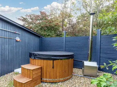 a hot tub with a black cover sitting next to a fence at 7 person holiday home in Vestervig-By Traum in Vestervig
