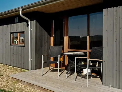 a patio with chairs and a table on a deck at 8 person holiday home in Ulfborg-By Traum in Ulfborg
