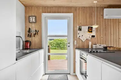a kitchen with a door leading to a patio at 813-Harboore-Neerlandiavej-136 in Harboør