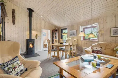 a living room with a table and a fireplace at BL1112-Saltum-Graabakken-26 in Saltum