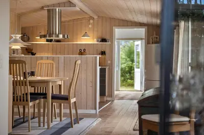 a kitchen with a table and chairs in a room at BL1107-Blokhus-Soren-Petersvej-16 in Blokhus