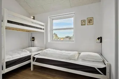 a bedroom with two bunk beds and a window at BL1118-Saltum-Vesterhavs-Sletten-37 in Saltum