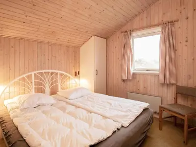 a bedroom with a large bed and a window at Spacious Retreat with Views - By Traum Ferienwohnungen in Blokhus