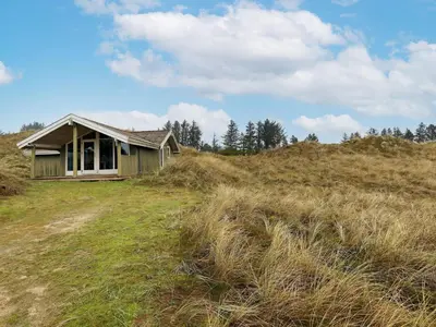 an old house on top of a grassy hill at Spacious Retreat with Views - By Traum Ferienwohnungen in Blokhus