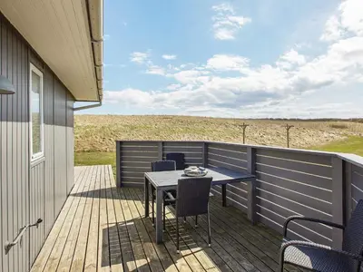 a patio with a table and chairs on a deck at 6 person holiday home in Lemvig in Lemvig