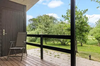 a chair on a deck with a view of a yard at LF10320-Hurup-Thy-Nattergalevej-2-B in Sønder Ydby