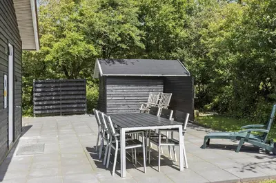 a table and chairs on a patio with a shed at LF101-Vestervig-Hellesvej-1 in Vestervig