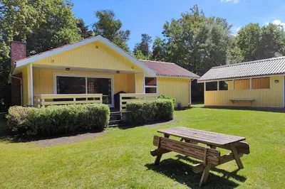 a yellow house with a picnic table in the yard at LF16244-Logstor-Mollysvej-44 in Løgstør
