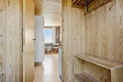 a kitchen with wooden walls and a white refrigerator at LF10314-Hurup-Thy-Edderfuglevej-15 in Sindrup