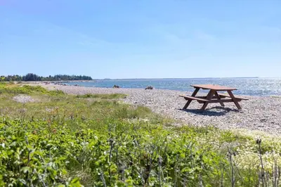 a picnic table on a beach near the water at LF10314-Hurup-Thy-Edderfuglevej-15 in Sindrup